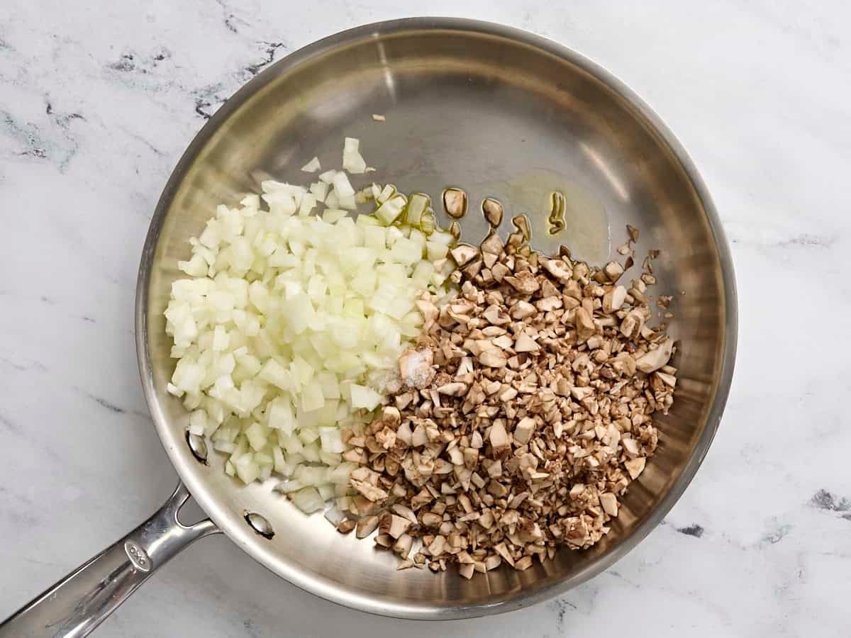 Diced mushrooms and onions in a skillet.