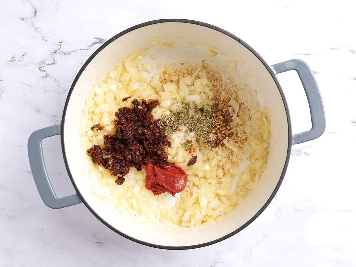 Adding the seasonings to the soup pot. 