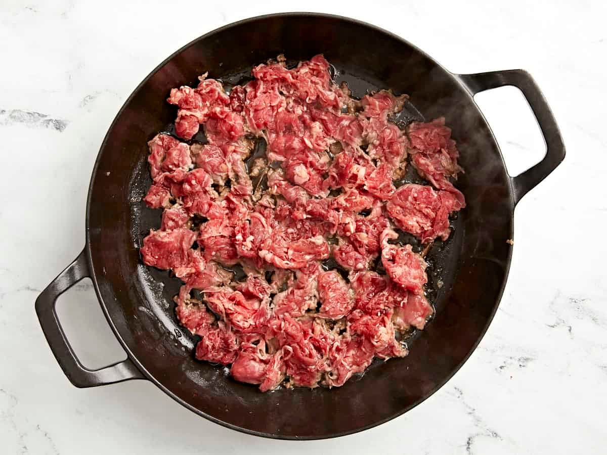Shaved beef added to skillet