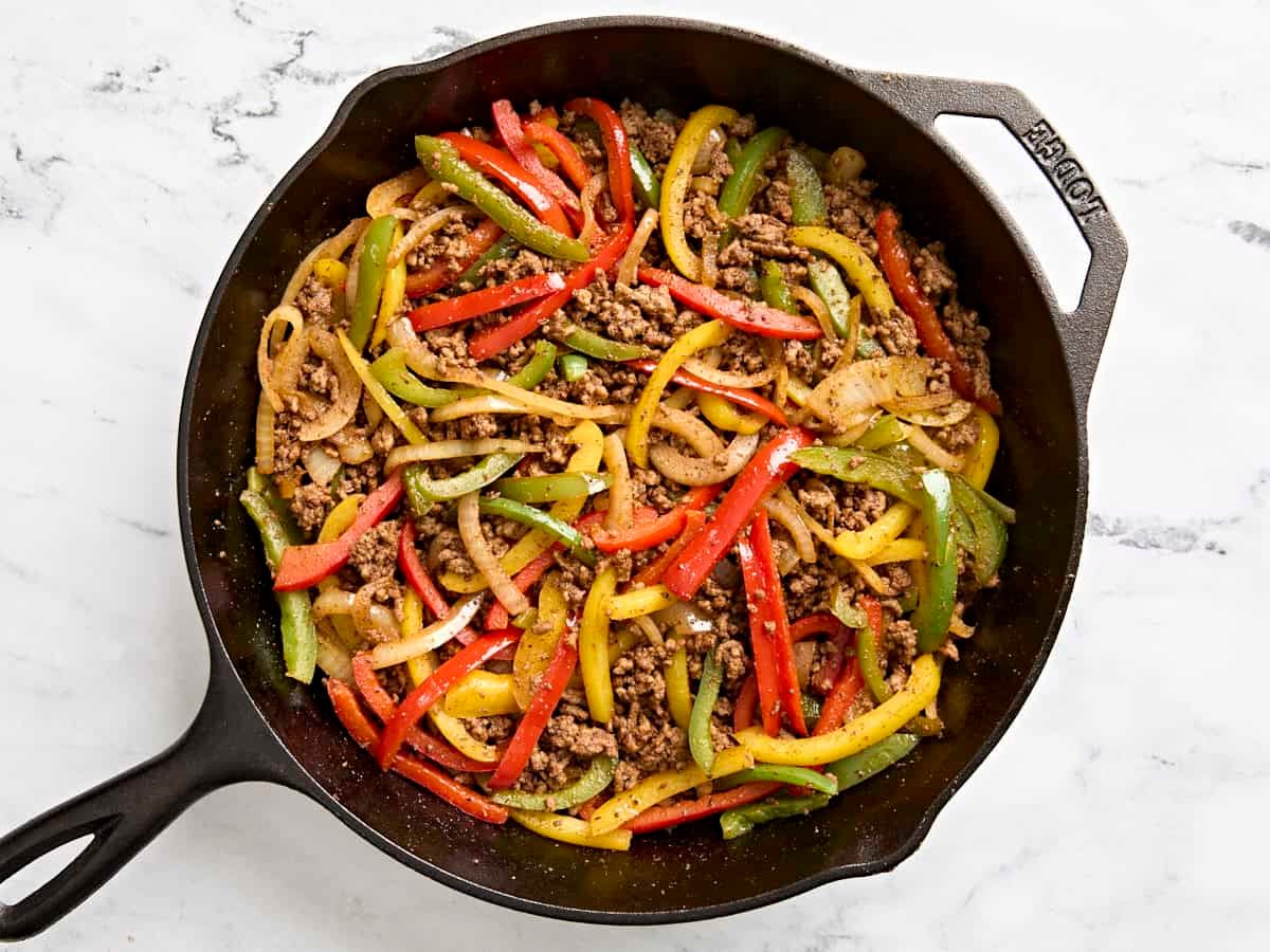Overhead view of ground beef fajitas in a cast iron skillet.