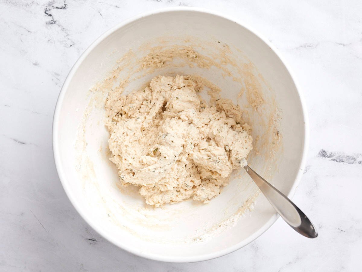 Dumpling dough in a bowl with a spoon.