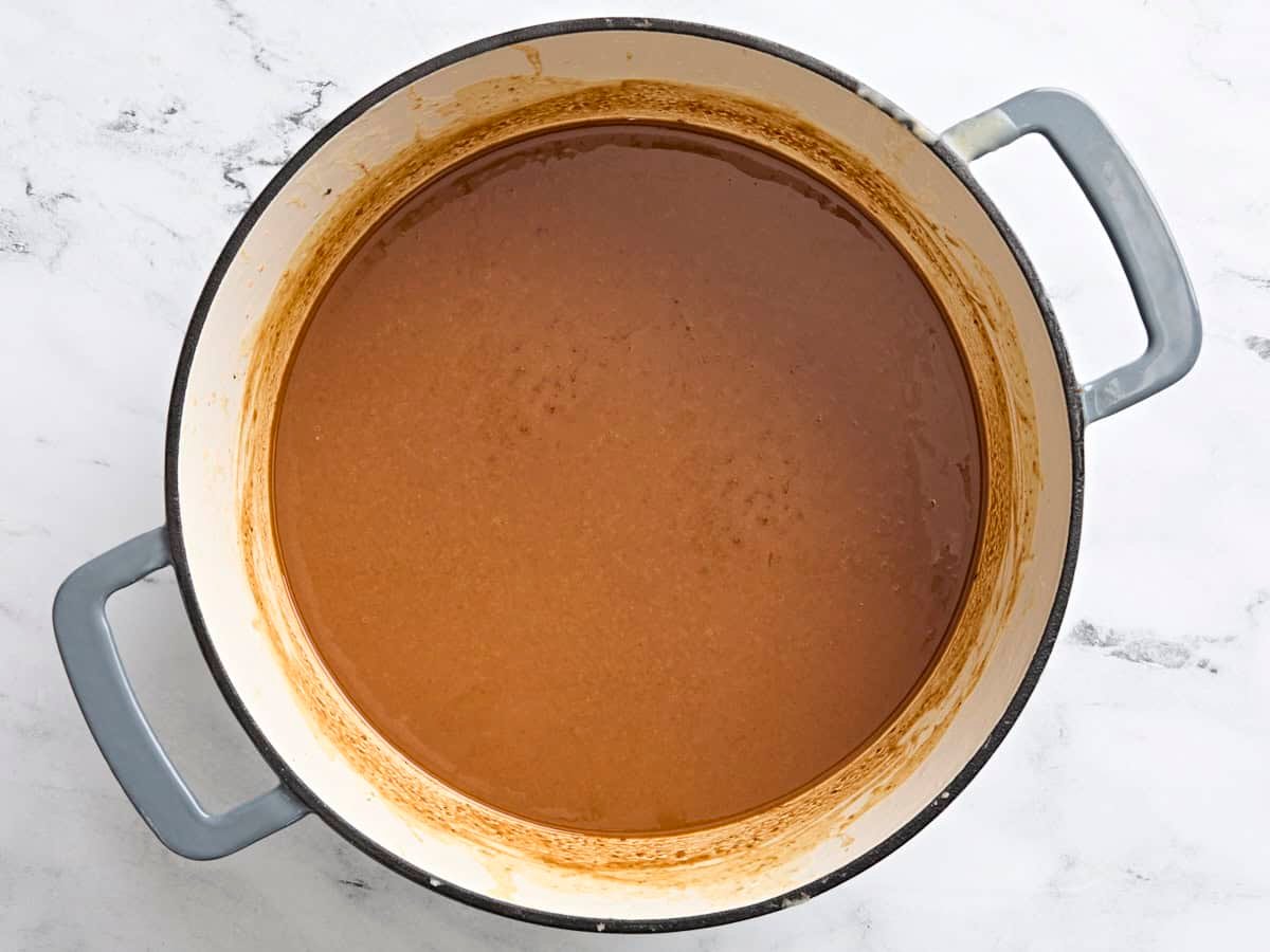 A dark brown roux in a pot.