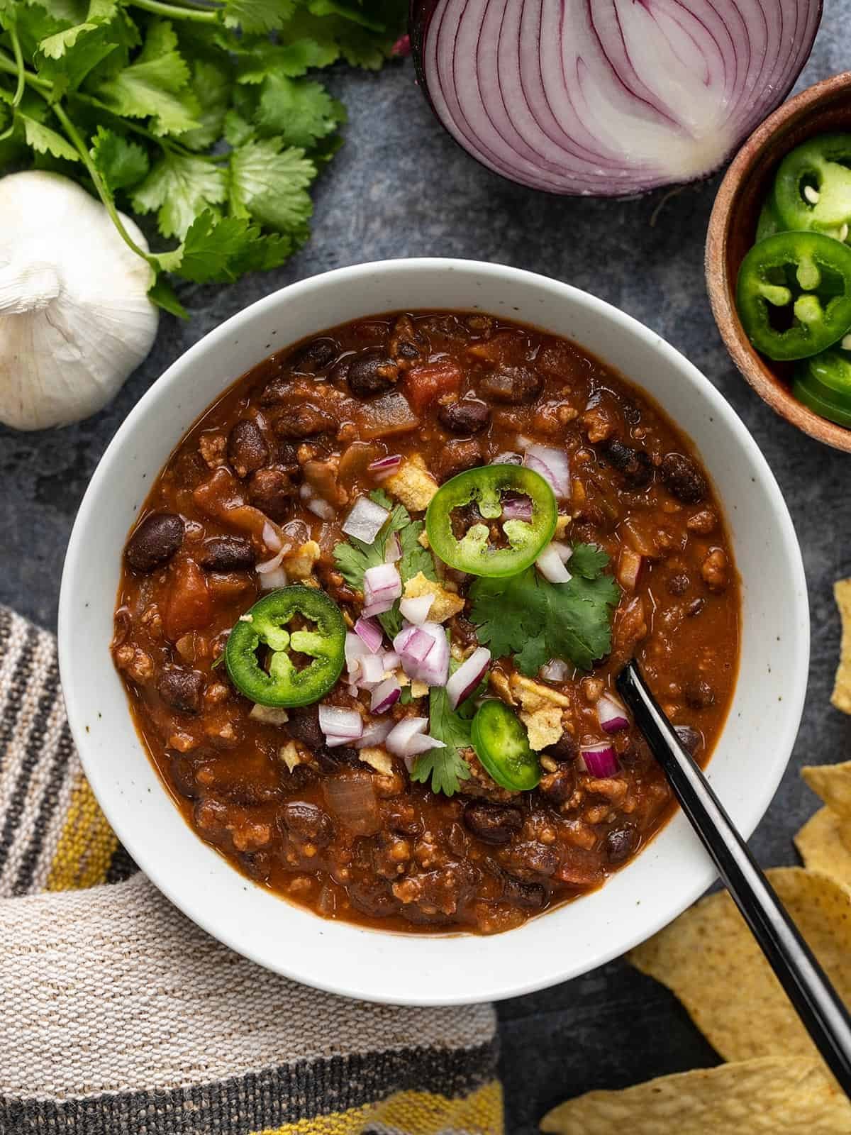 Overhead view of a bowl full of black bean chili with toppings.