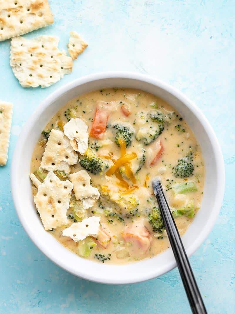 overhead view of broccoli cheddar soup with crumbled saltine crackers