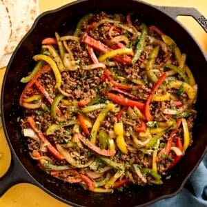 Overhead view of ground beef fajitas filling in a skillet.