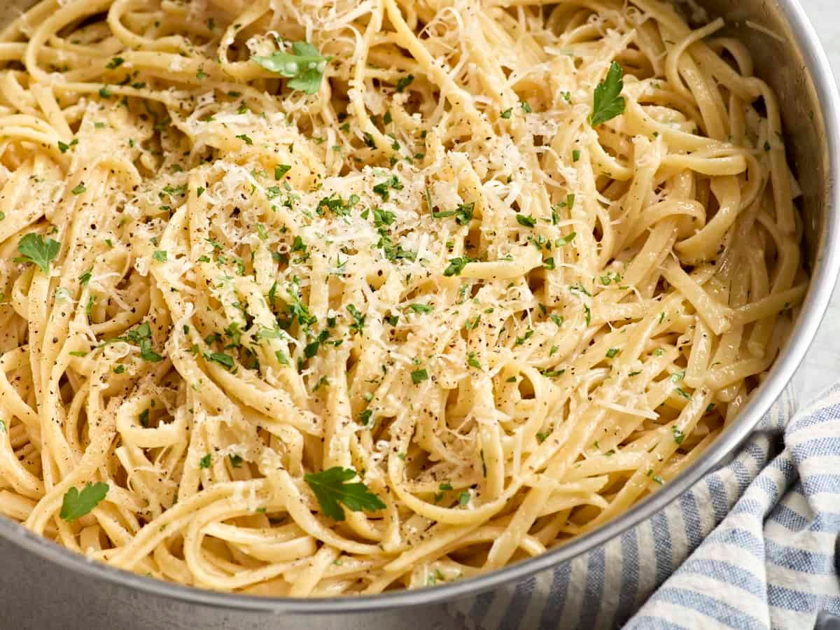 Side close up of a skillet of traditional fettuccine alfredo.