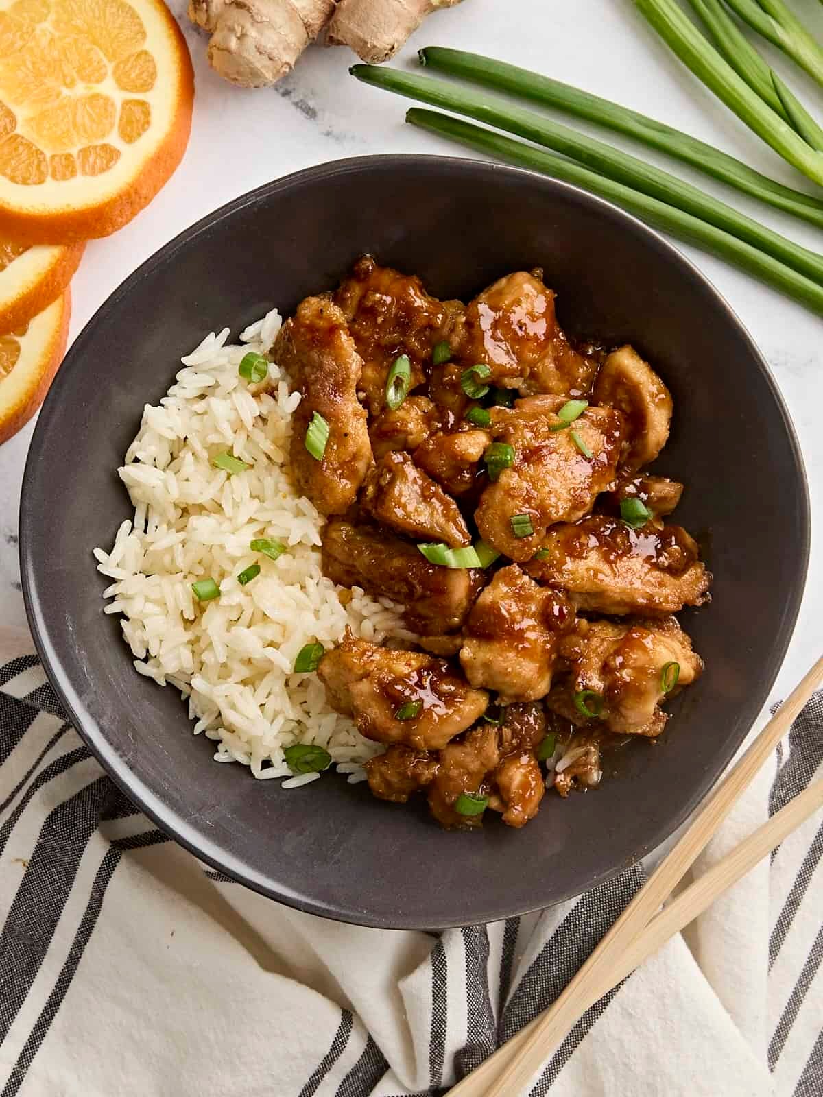 Overhead view of homemade orange chicken in a bowl with rice.