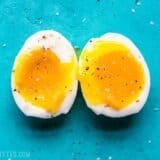a soft boiled egg cut in half on a blue background