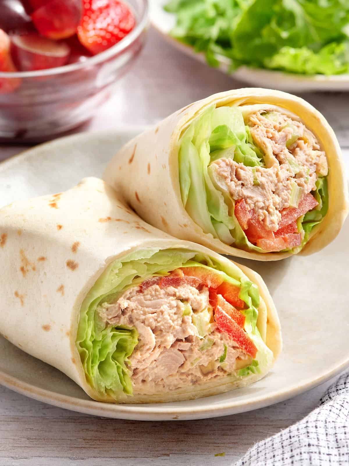 A tuna wrap sliced in half on a plate.